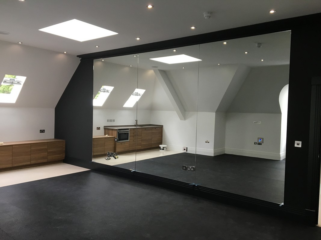 Frameless glass wall dividing loft conversion in St John's Wood